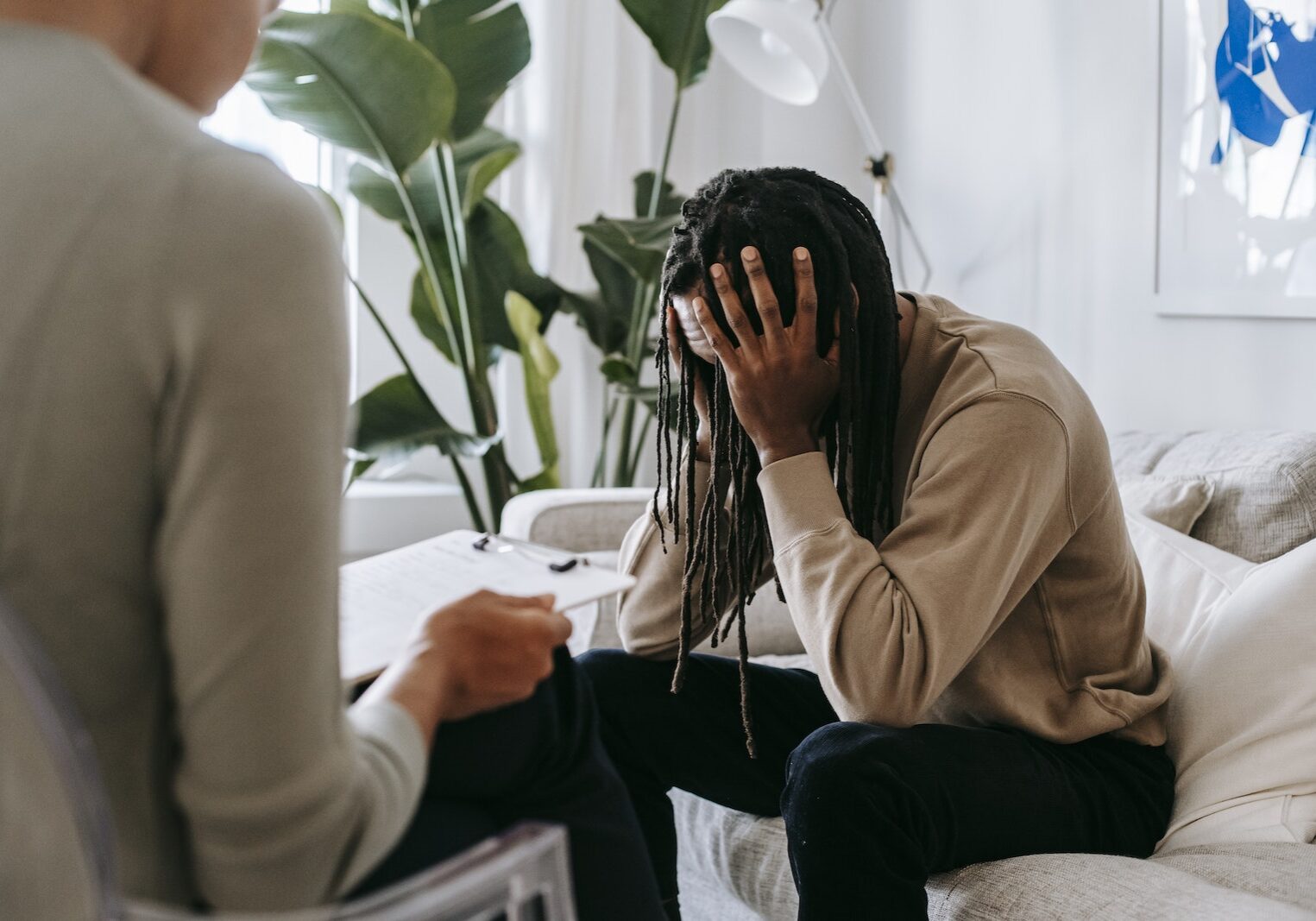 Stressed black man with dreadlocks in psychological office